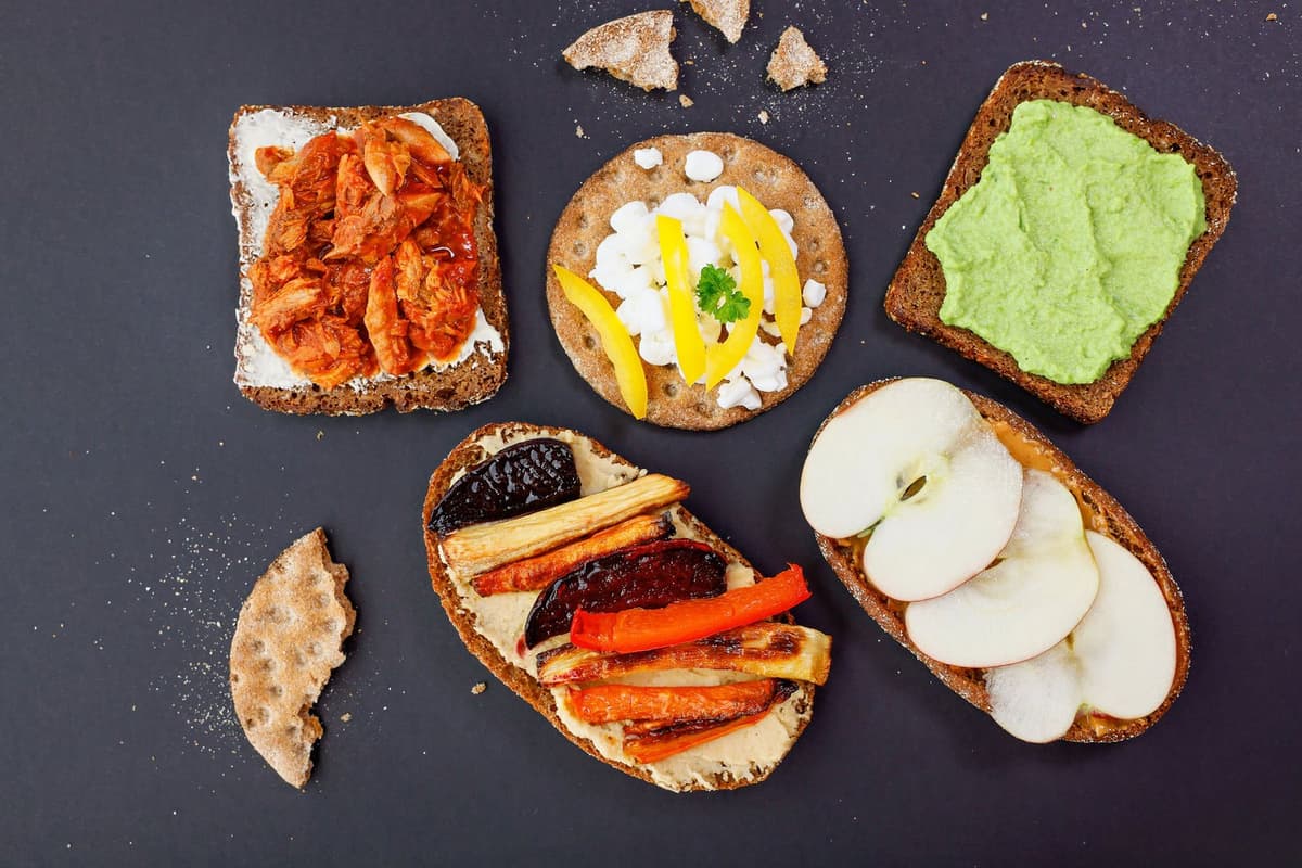 Fem olika smörgåsar med varierande pålägg - som frukt, rotfrukter, ost, avocadoröra och tomatbaserad fiskröra.