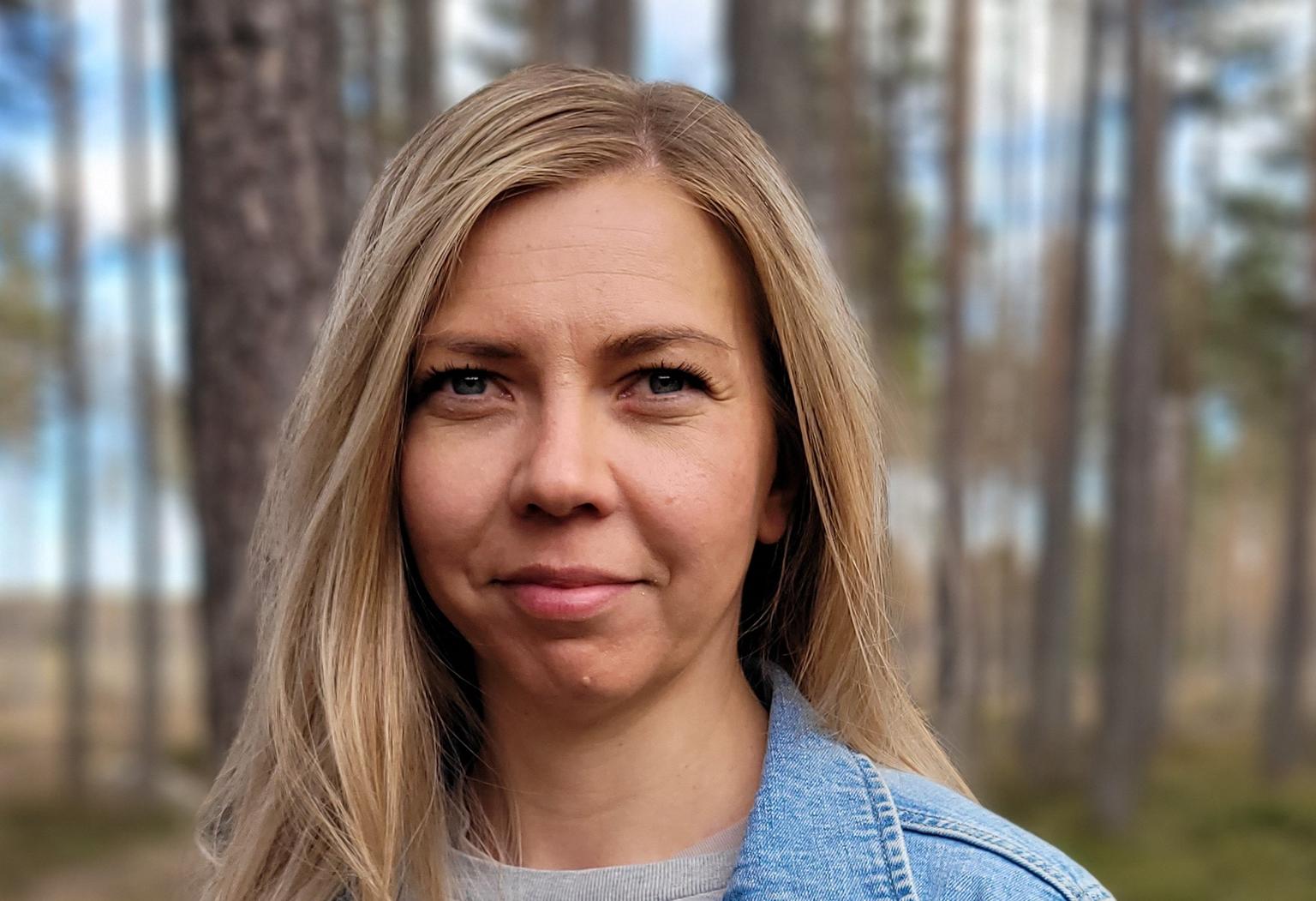 Lähikuva naisesta, joka seisoo luonnossa.