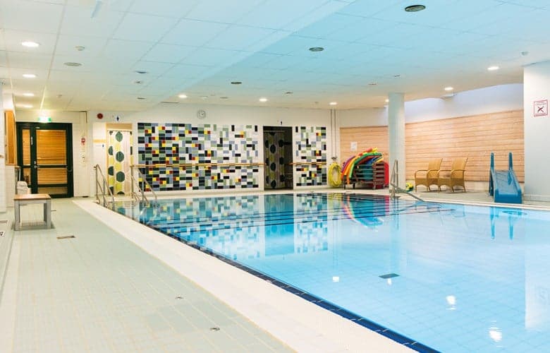 Vattnet skimrar under den ljusa belysningen i simhallen.