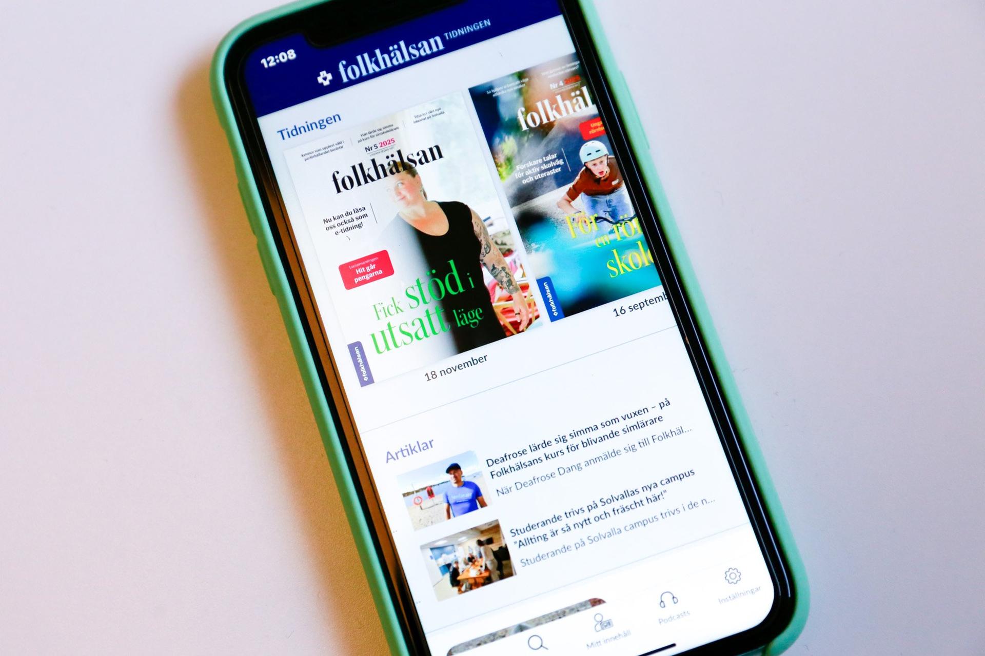 En mobiltelefon med appen Tidningen Folkhälsan öppen