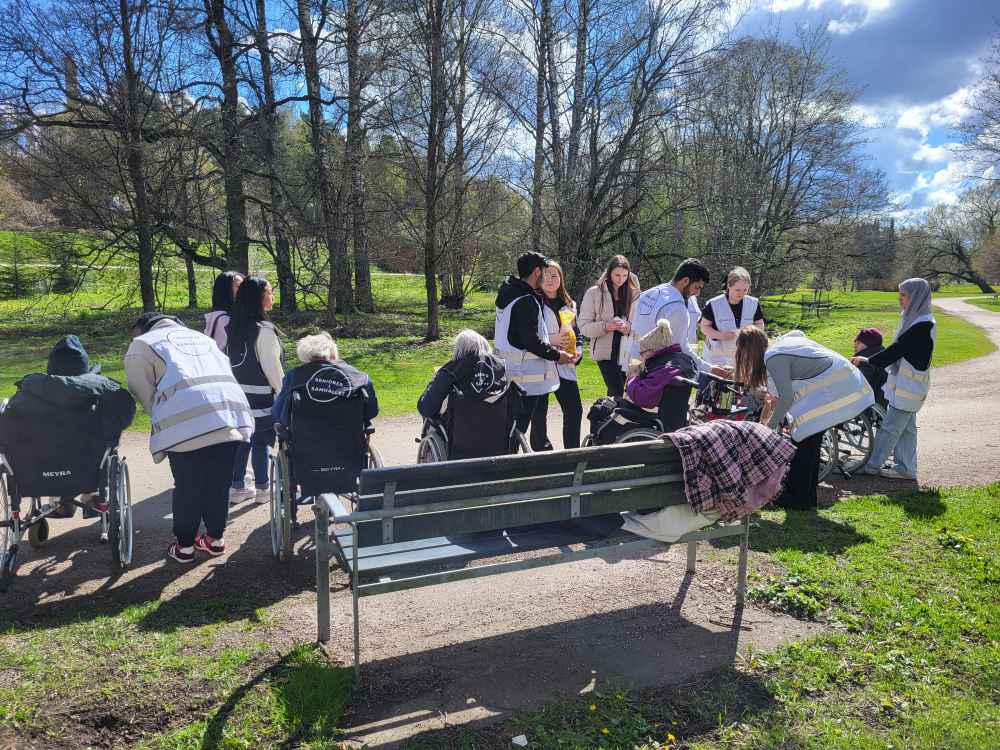 V&aring;rdare och &auml;ldre har en picknick i en solig park.