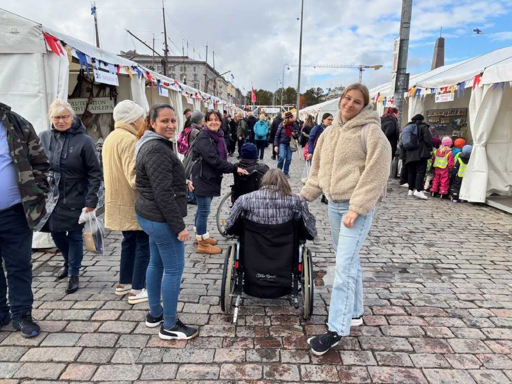 Ett par &auml;ldre tillsammans med v&aring;rdare och v&aring;rdstuderande mitt i folkvimlet p&aring; Str&ouml;mmingsmarknaden.